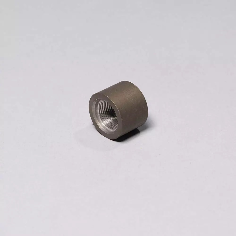 Metal threaded pipe cap on gray background.