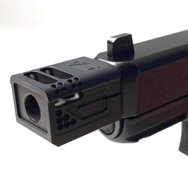 Close-up of firearm muzzle brake on gun barrel.
