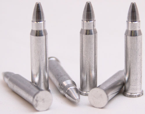 Five metallic bullet casings on a surface.