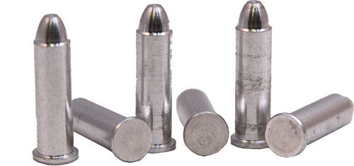 Five metal bullet casings on a white surface.