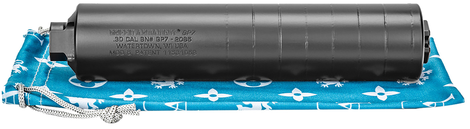 Black firearm suppressor on blue cloth
