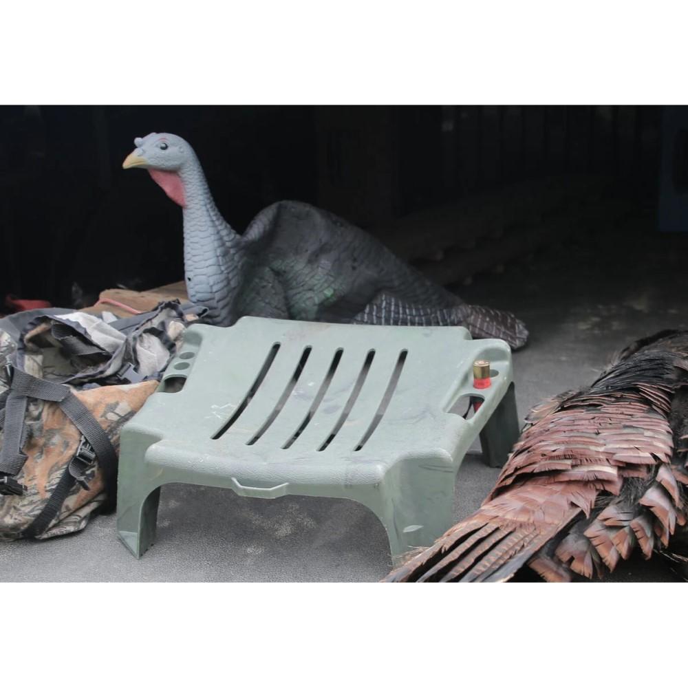 Plastic chair with turkey decoys and gear nearby.