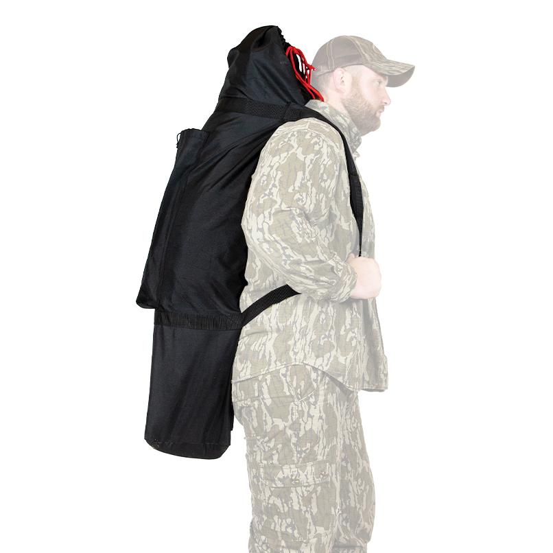 Person wearing a large black backpack outdoors.