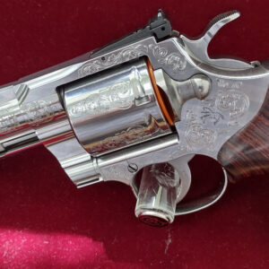 Close-up of a polished revolver on red fabric.