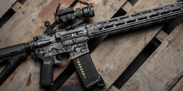 Black rifle on wooden surface