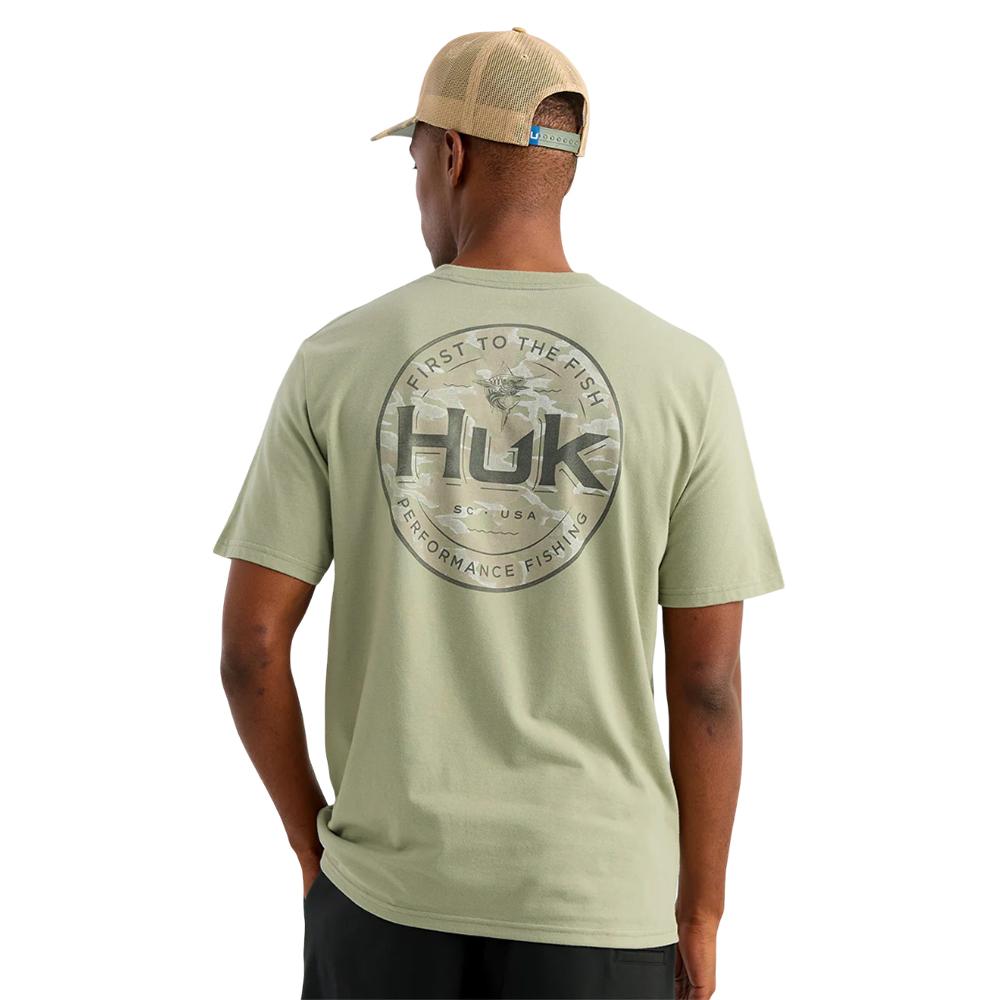 Man wearing green Huk fishing T-shirt back view