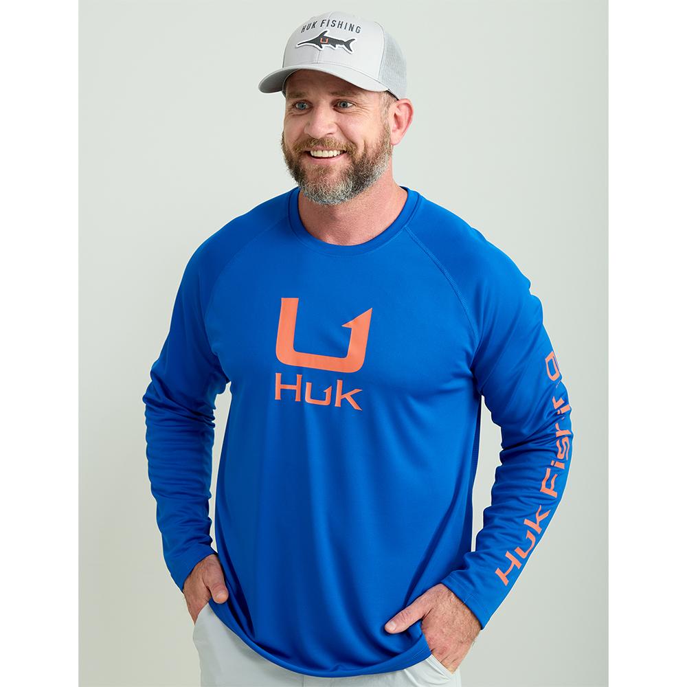Man wearing blue Huk Fishing shirt and cap
