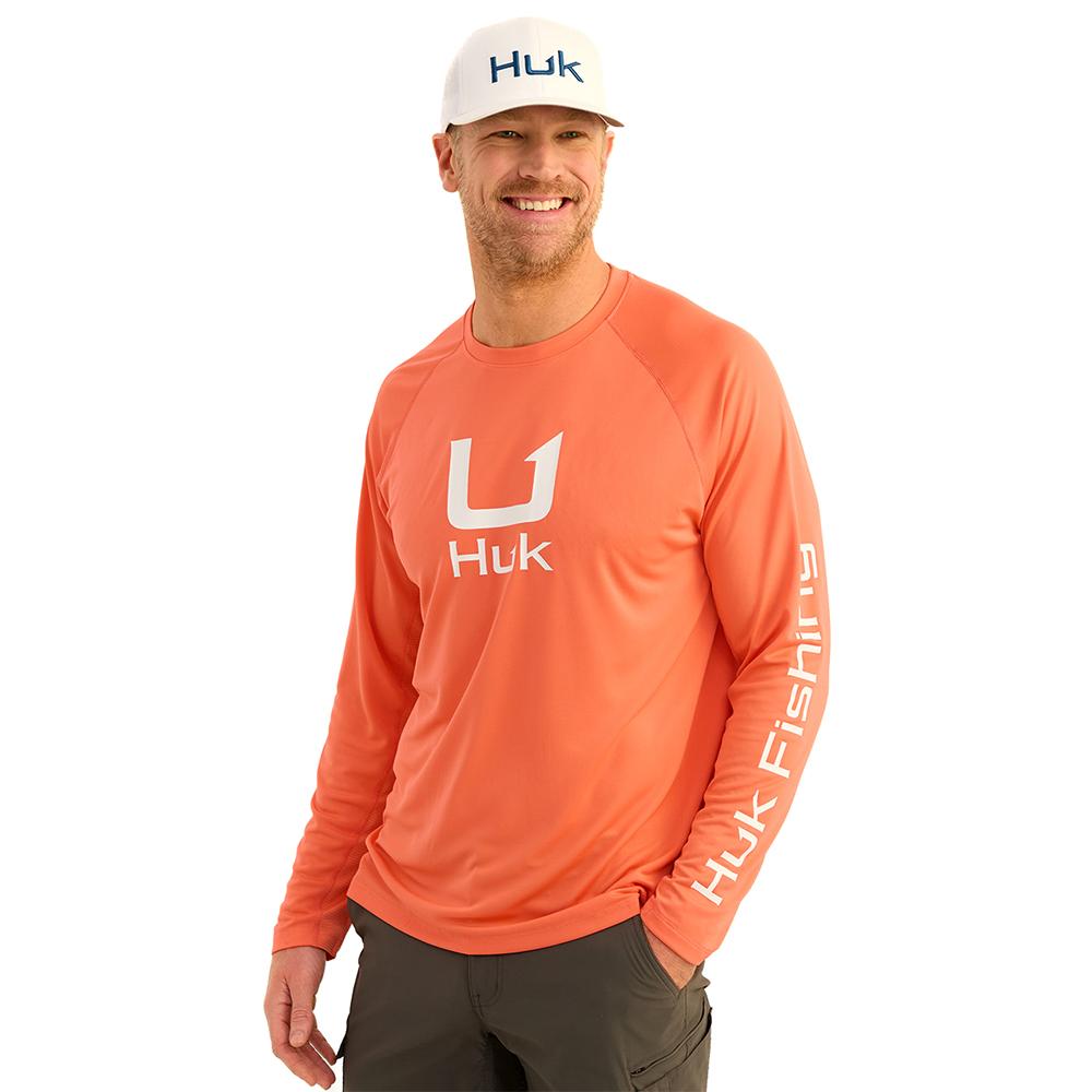 Man wearing orange Huk fishing shirt and hat