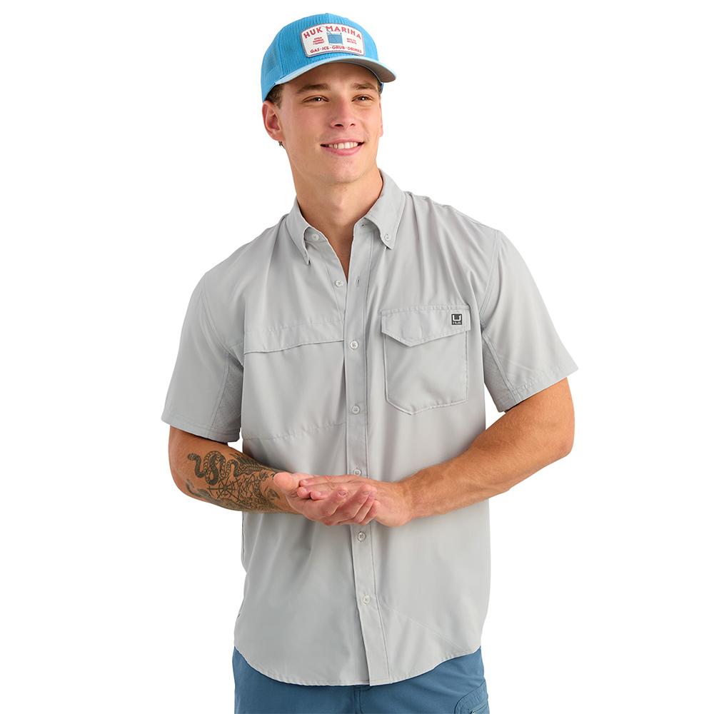 Man wearing gray button-up shirt and blue cap