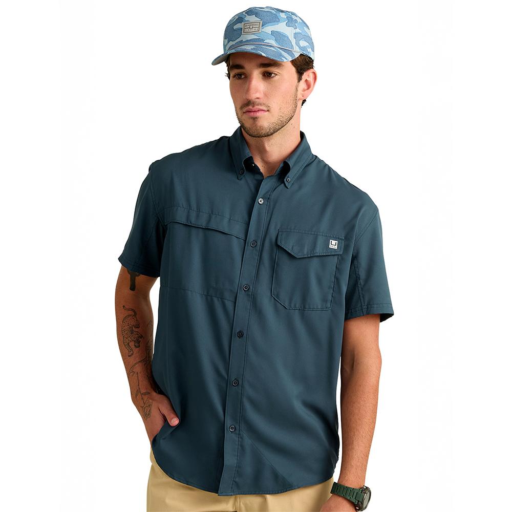 Man wearing teal short-sleeve shirt and cap