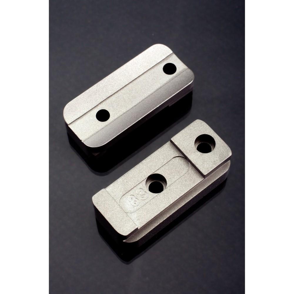 Two machined aluminum blocks with drilled holes