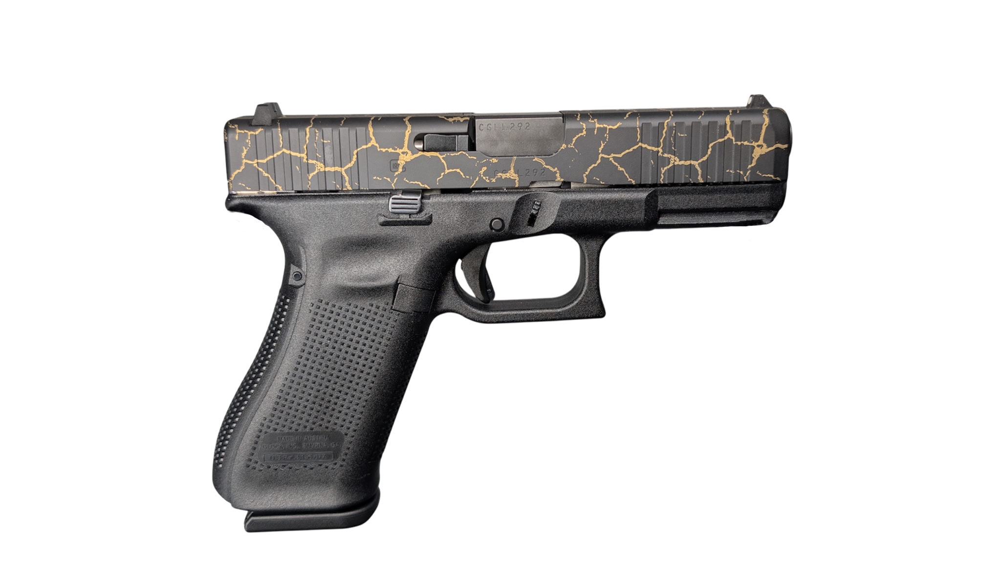 Black handgun with gold crack-pattern slide