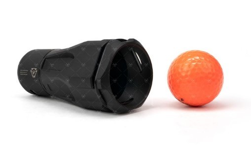 Black cylindrical device beside orange golf ball