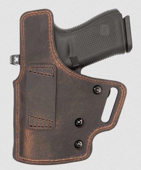 Handgun in brown leather concealed carry holster