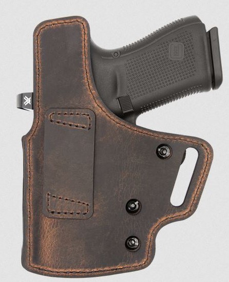Handgun in brown leather concealed carry holster