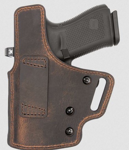 Handgun in brown leather belt holster