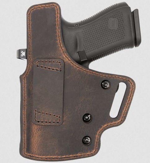 Handgun in brown leather belt holster