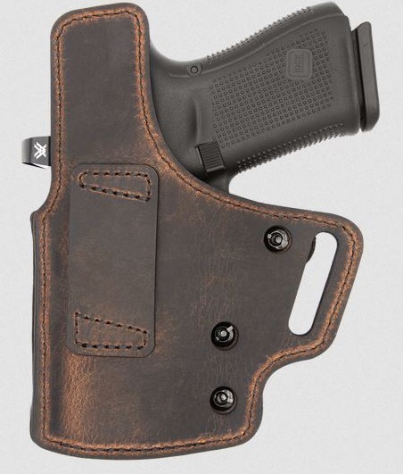 Handgun in brown leather concealed carry holster