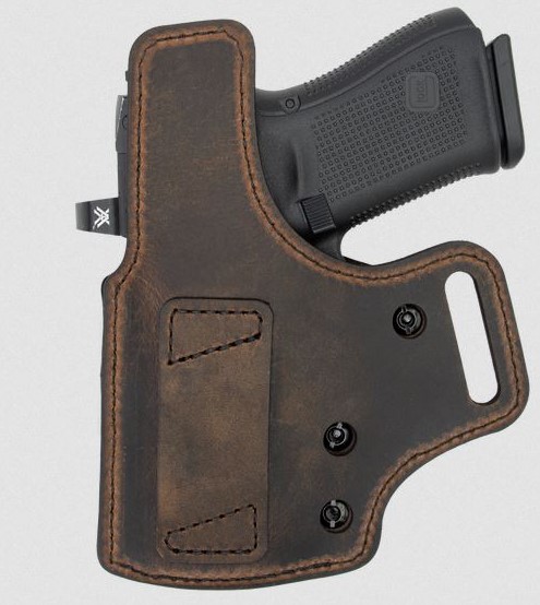 Handgun in brown leather belt holster