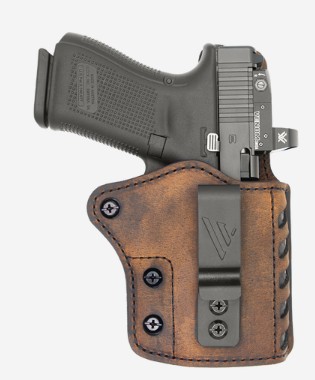 Handgun in brown leather holster with belt clip