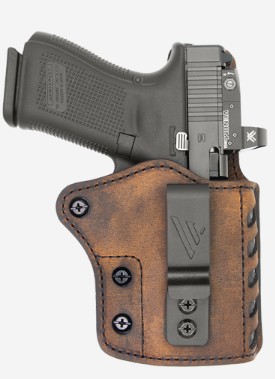 Handgun in brown leather holster with belt clip