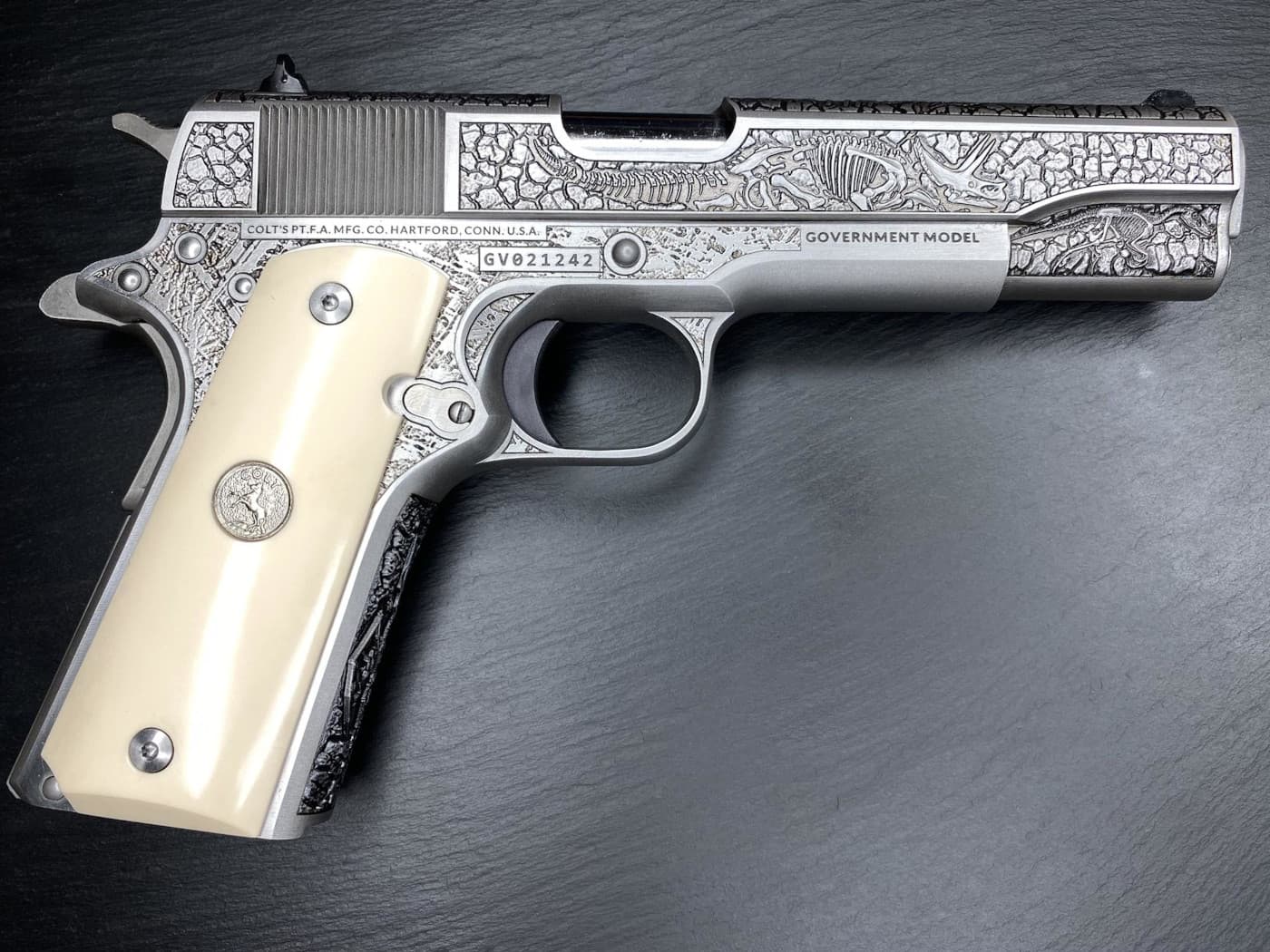 Engraved Colt 1911 pistol with ivory grips