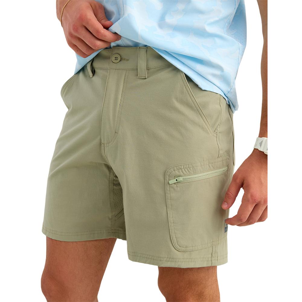 Man wearing light green cargo shorts with zipper pocket