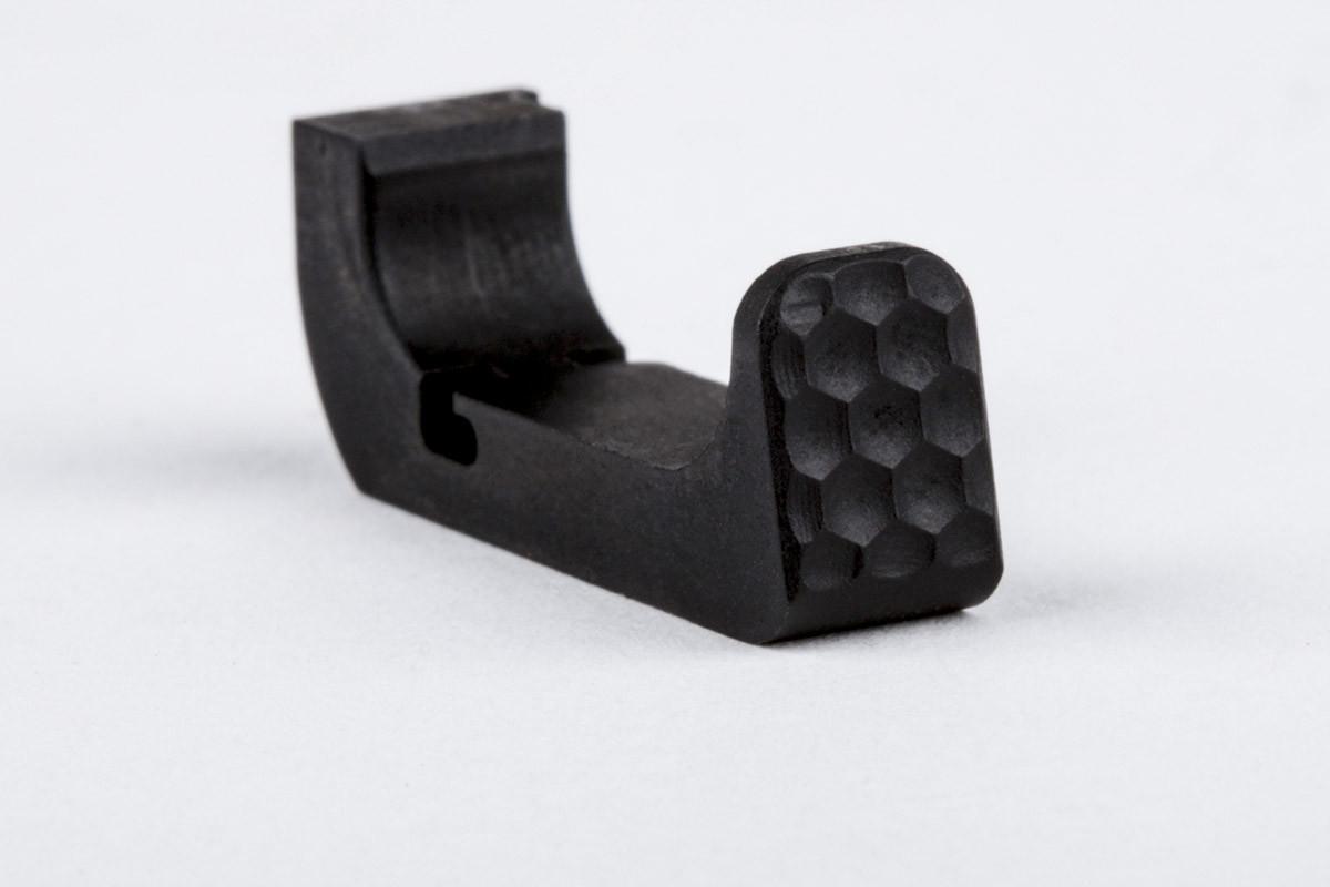 Black metal firearm trigger component with textured face