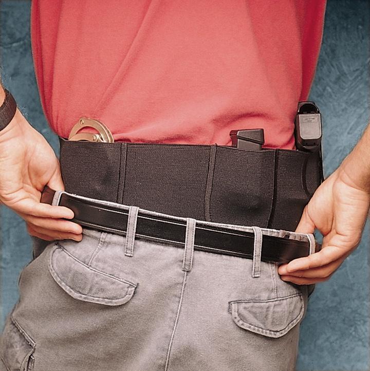 Person securing concealed handgun inside waistband holster