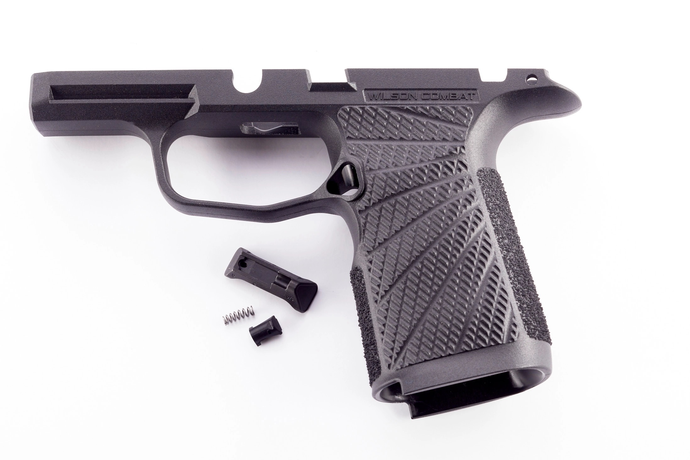 Black handgun frame with textured grip and parts
