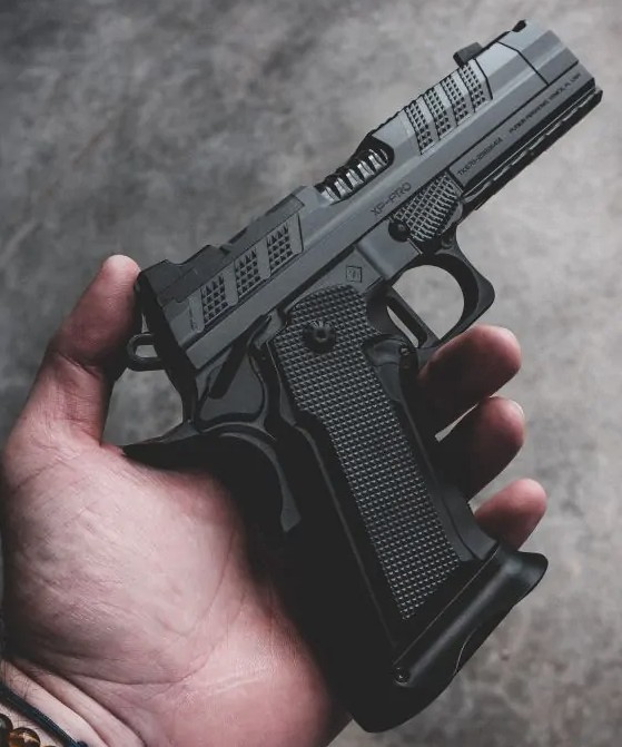Hand holding a black semi-automatic pistol
