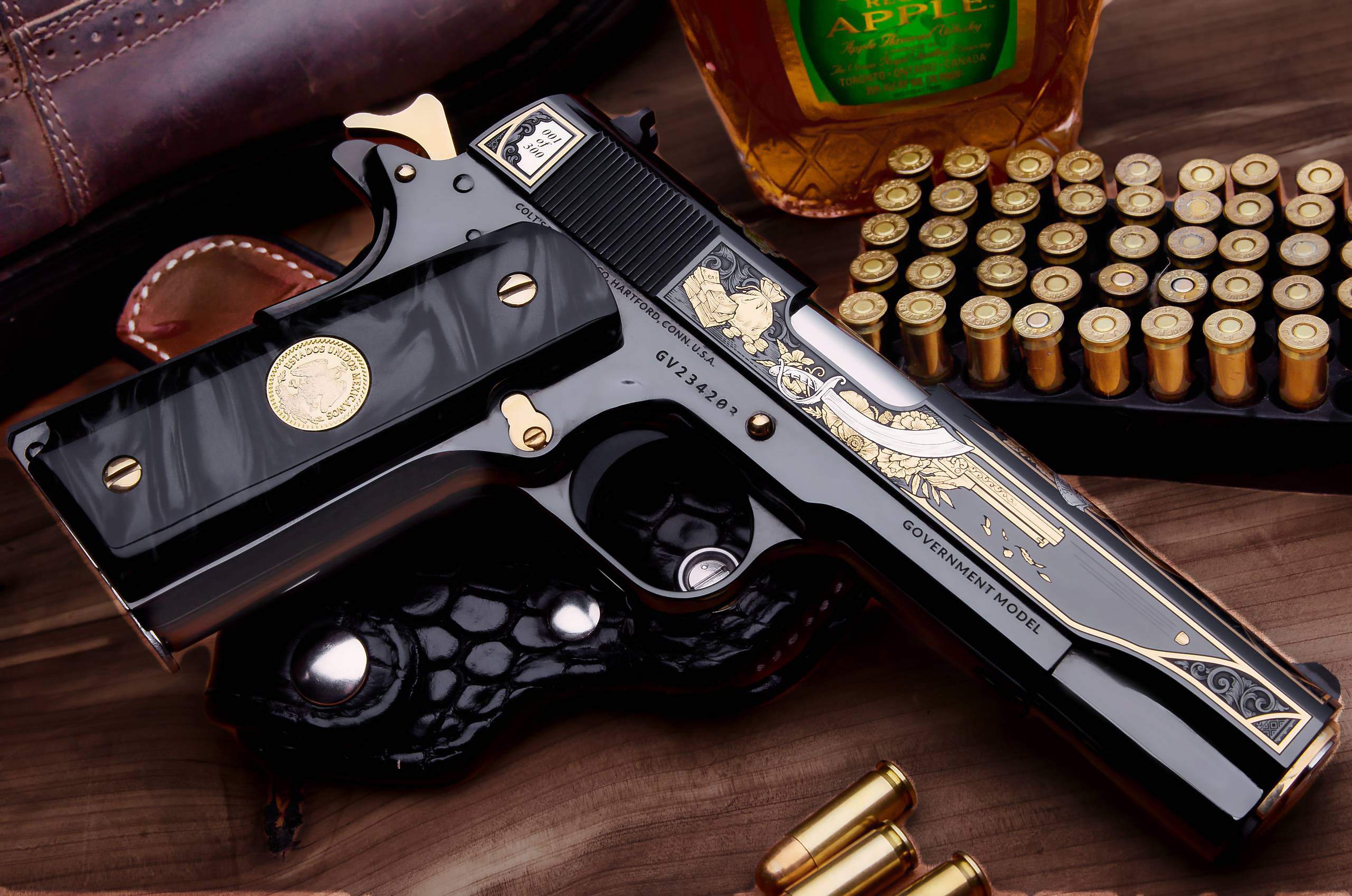 Engraved Colt 1911 pistol with ammunition and whiskey