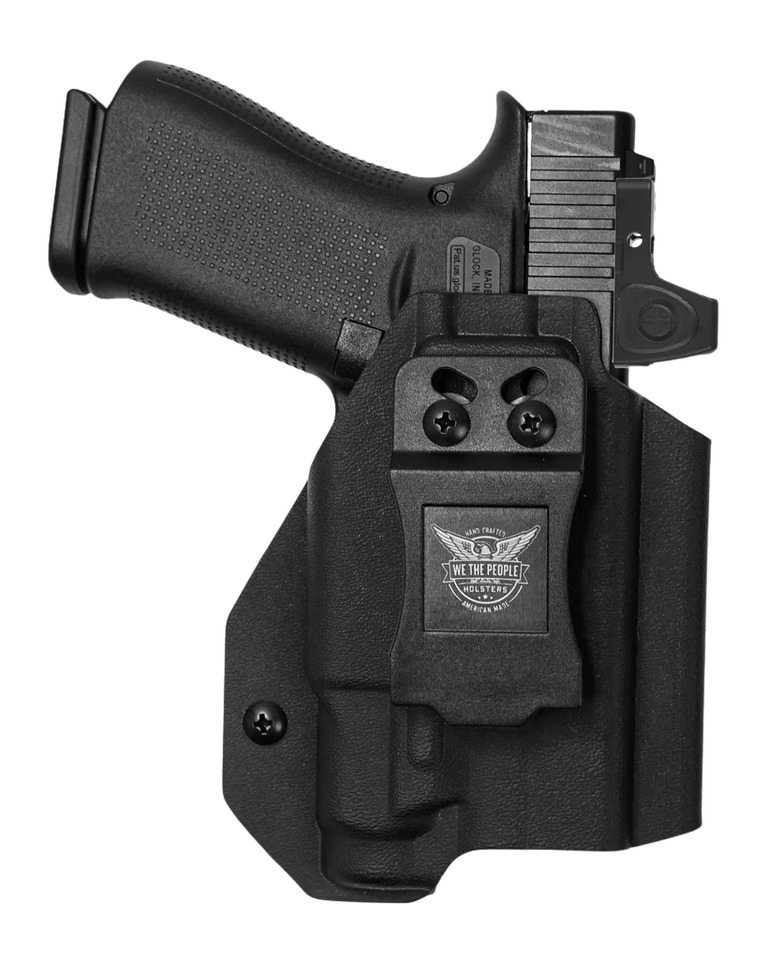 Black handgun in kydex holster with belt clip