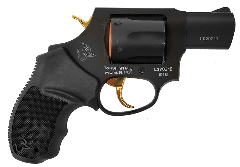 Black Taurus revolver with gold trigger on white background