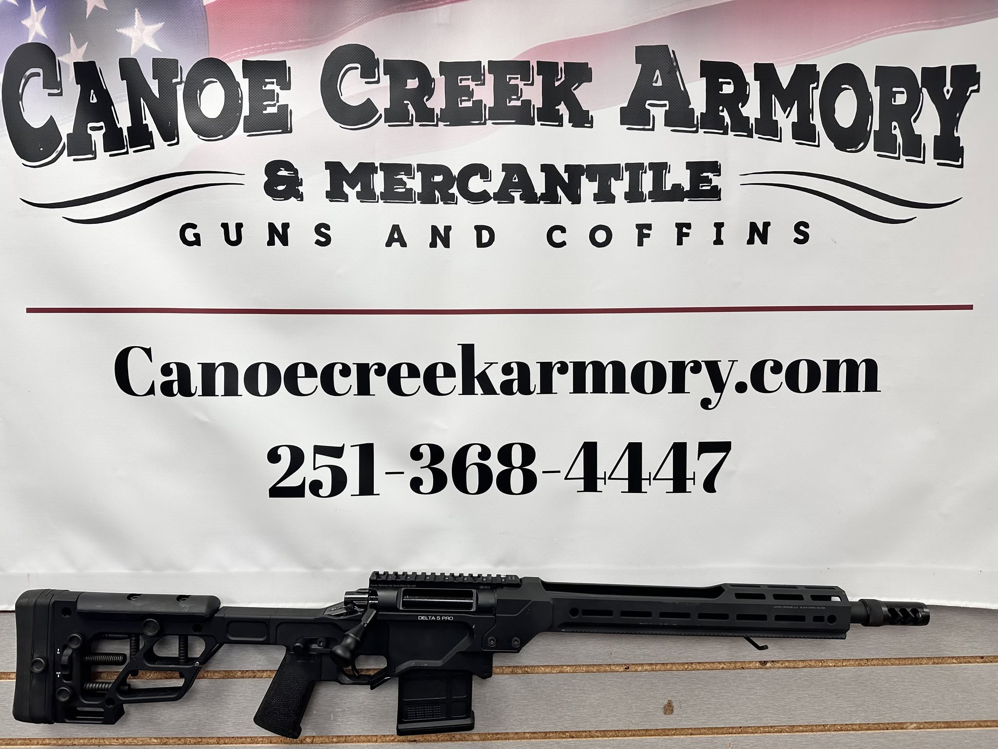 Rifle displayed beneath Canoe Creek Armory banner