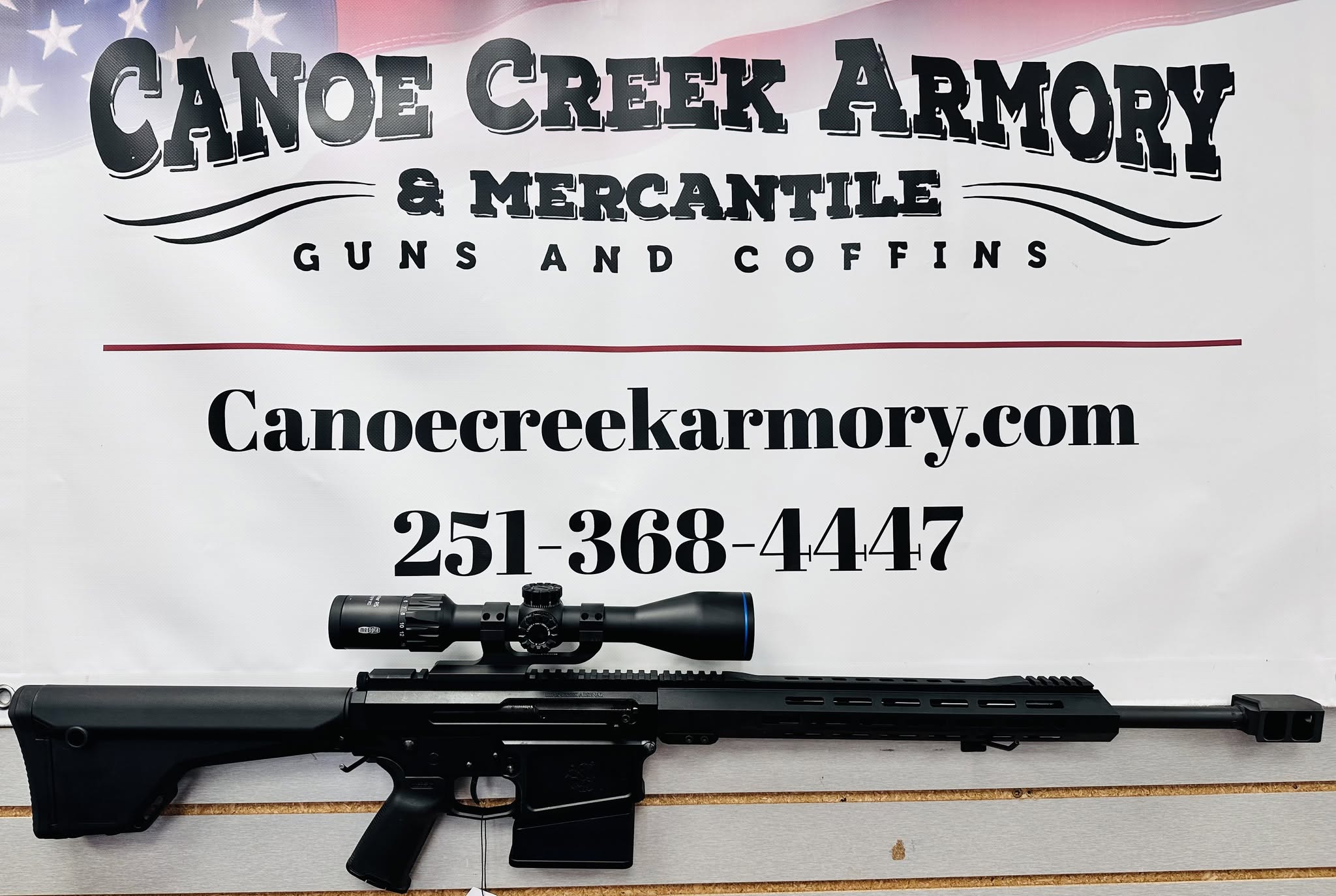 Scoped rifle displayed in front of armory sign