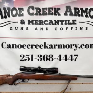 Scoped hunting rifle beneath armory banner