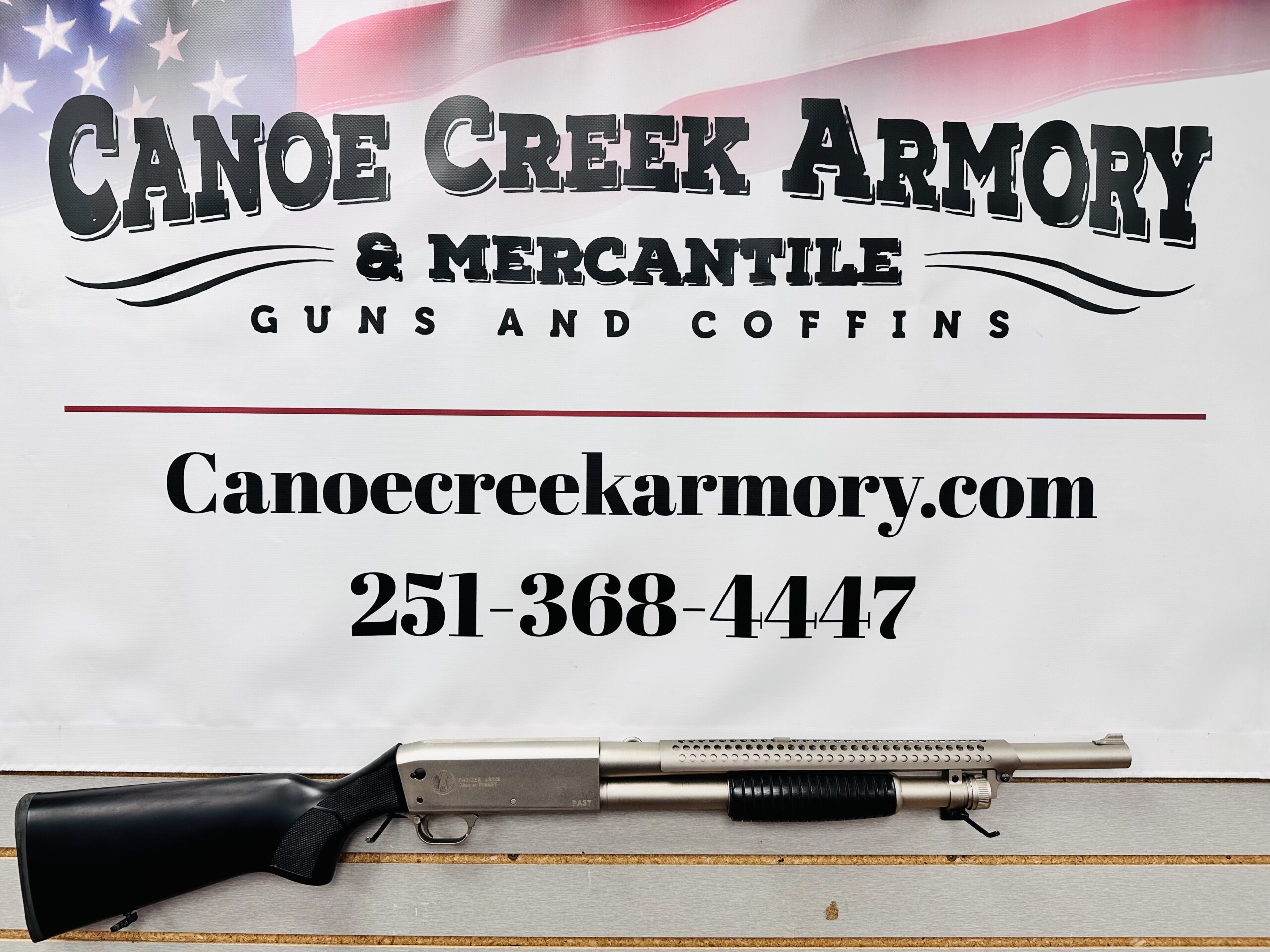 Shotgun displayed beneath Canoe Creek Armory sign