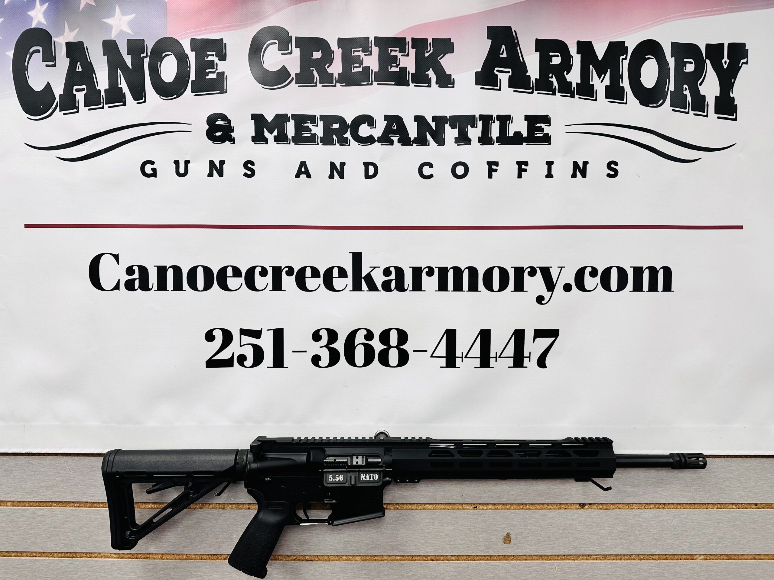 Rifle displayed beneath Canoe Creek Armory sign