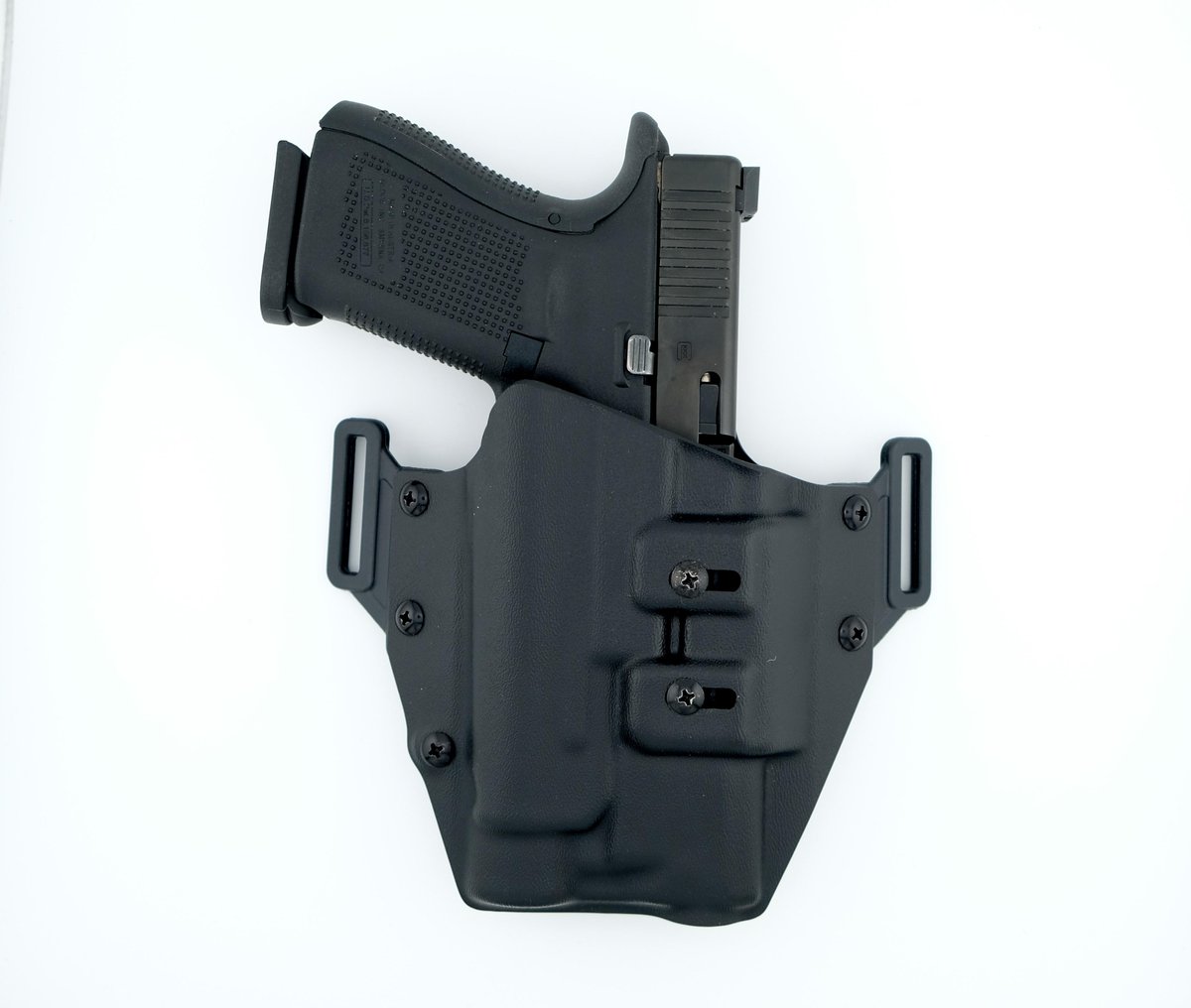 Black handgun in molded holster on white background