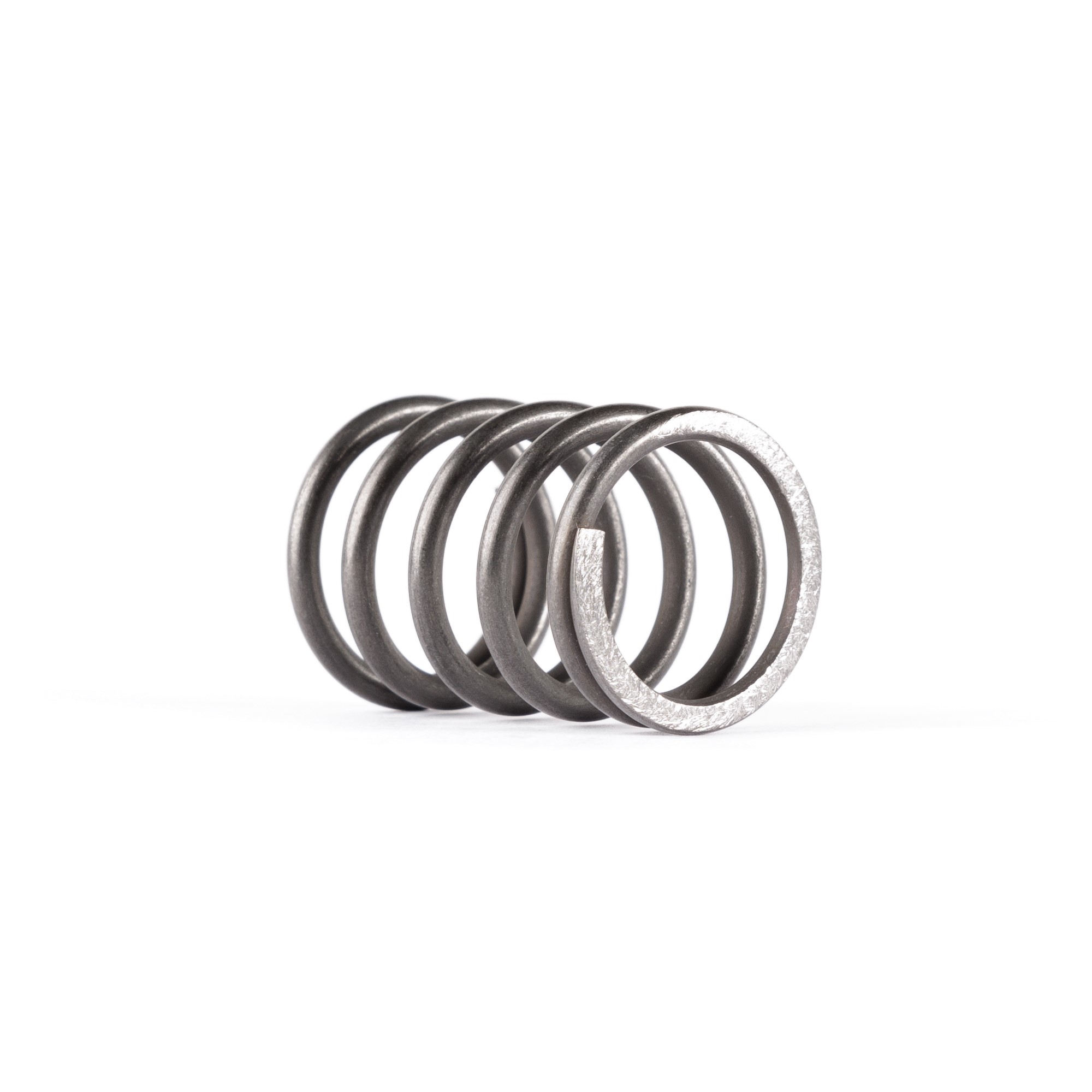 Close-up of a dark metal compression spring